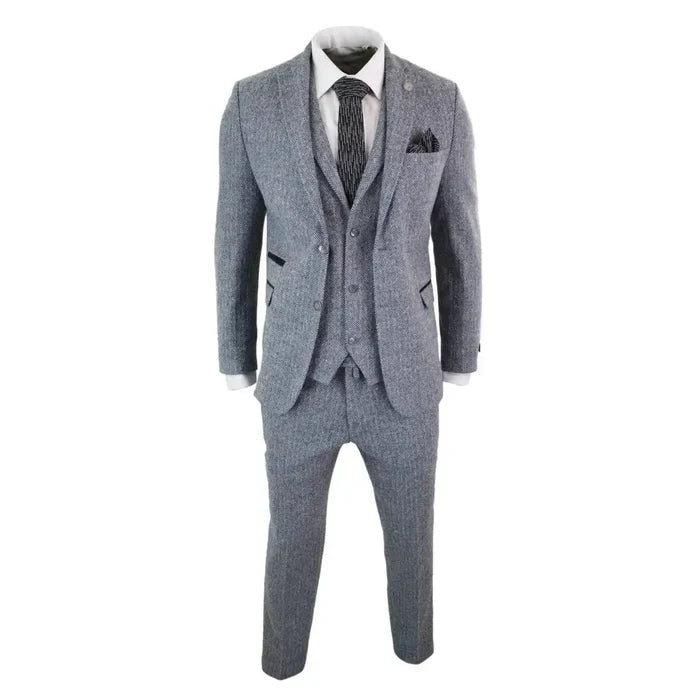 Close-up of men's grey herringbone tweed suit with notch lapel blazer, matching waistcoat, and trousers, styled with white shirt and black tie