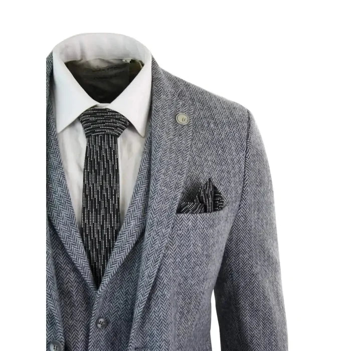 Men's light grey herringbone tweed suit jacket with notch lapel, silver lapel pin, and matching pocket square, tailored fit for formal occasions.