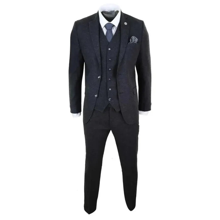 Close-up of men's dark grey wool tweed suit with blazer, vest, white shirt, and blue tie, featuring a pocket square for a classic look.