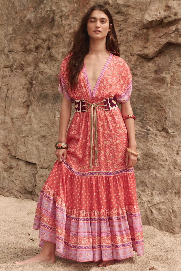 Front view of Sunshine Bandit Gown in Cayenne, deep V-neck, tassel ties, tiered border-print skirt, styled with wide belt