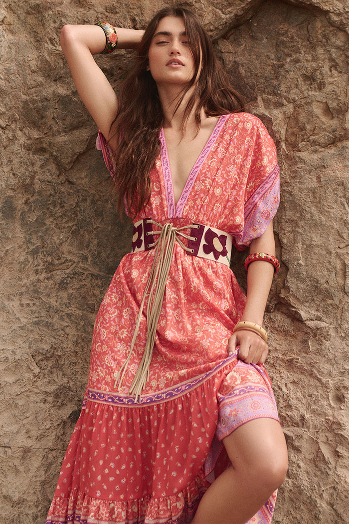 Front view of Sunshine Bandit Gown, deep V-neckline, border print hem, tiered skirt, styled with tassel belt