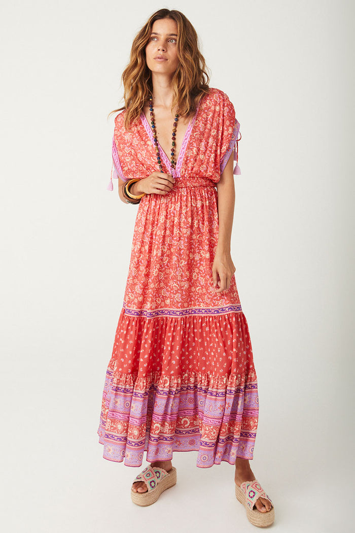 Cayenne red floral boho maxi gown flat lay showing tiered skirt, border print hem, and tassel-trim shoulder ties