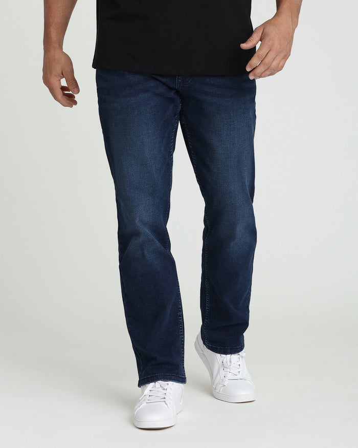 Man wearing midnight blue straight-leg jeans with black t-shirt and white sneakers.
