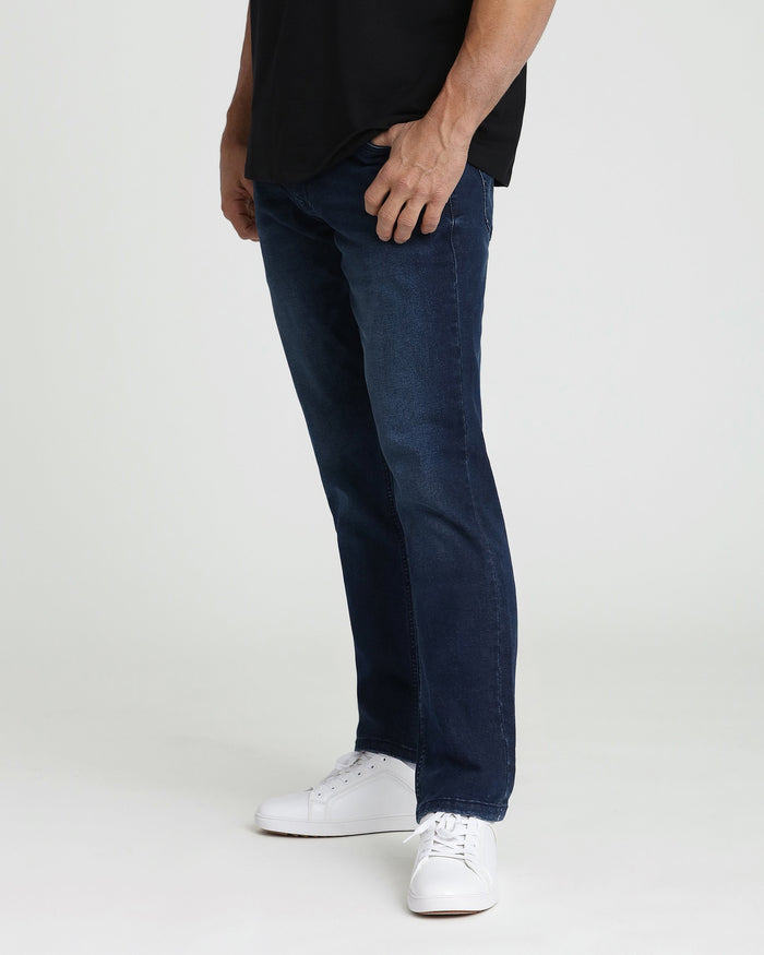 Man wearing midnight blue straight-leg jeans with black t-shirt and white sneakers.