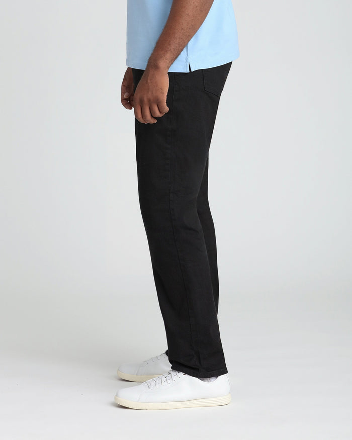 Black pants with relaxed fit and thigh pocket, styled with light blue shirt and white sneakers.