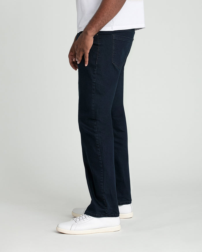 Man wearing deep blue straight-leg jeans and white sneakers with white t-shirt.