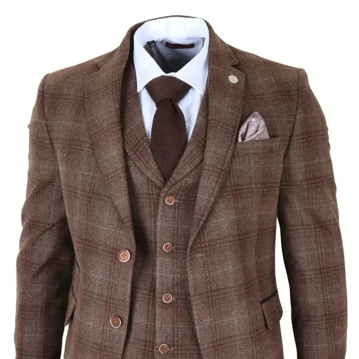 Men's brown tweed check 3-piece suit with tailored blazer, matching waistcoat, and trousers, featuring a white shirt, brown tie, pocket square, and lapel pin