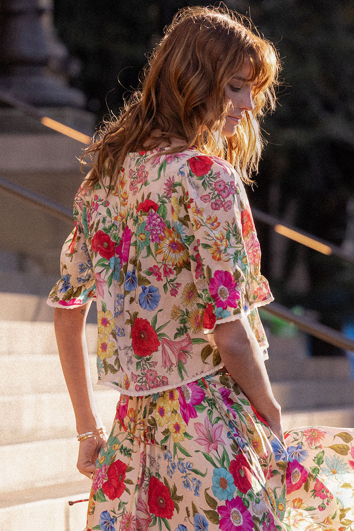 Back view of Valley of the Dolls Blouse in Opal, showing contrast lace trim and elastic sleeve detail, worn outdoors