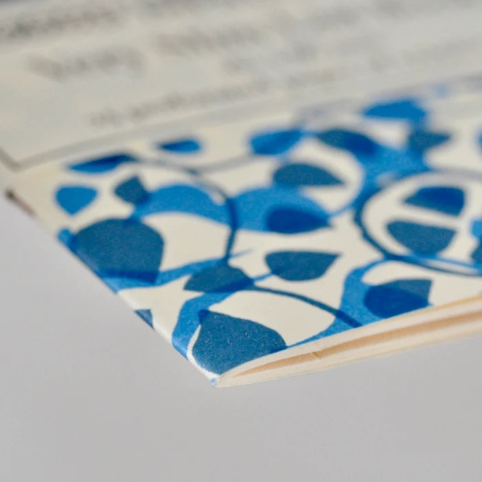 Close-up of a notebook with blue and white geometric pattern on a gray background