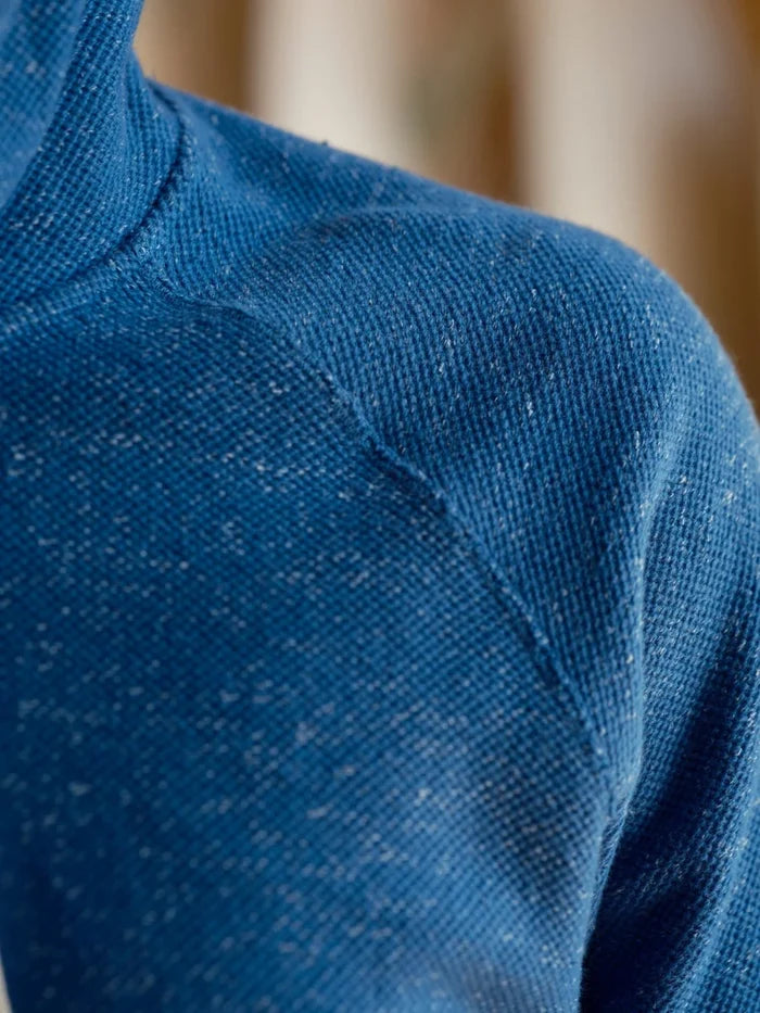 Close-up detail of the Mollusk Surf Shop Whale Patch Pullover in Marine, showing the nubby twisted French terry fabric texture and raglan shoulder seam in marine blue